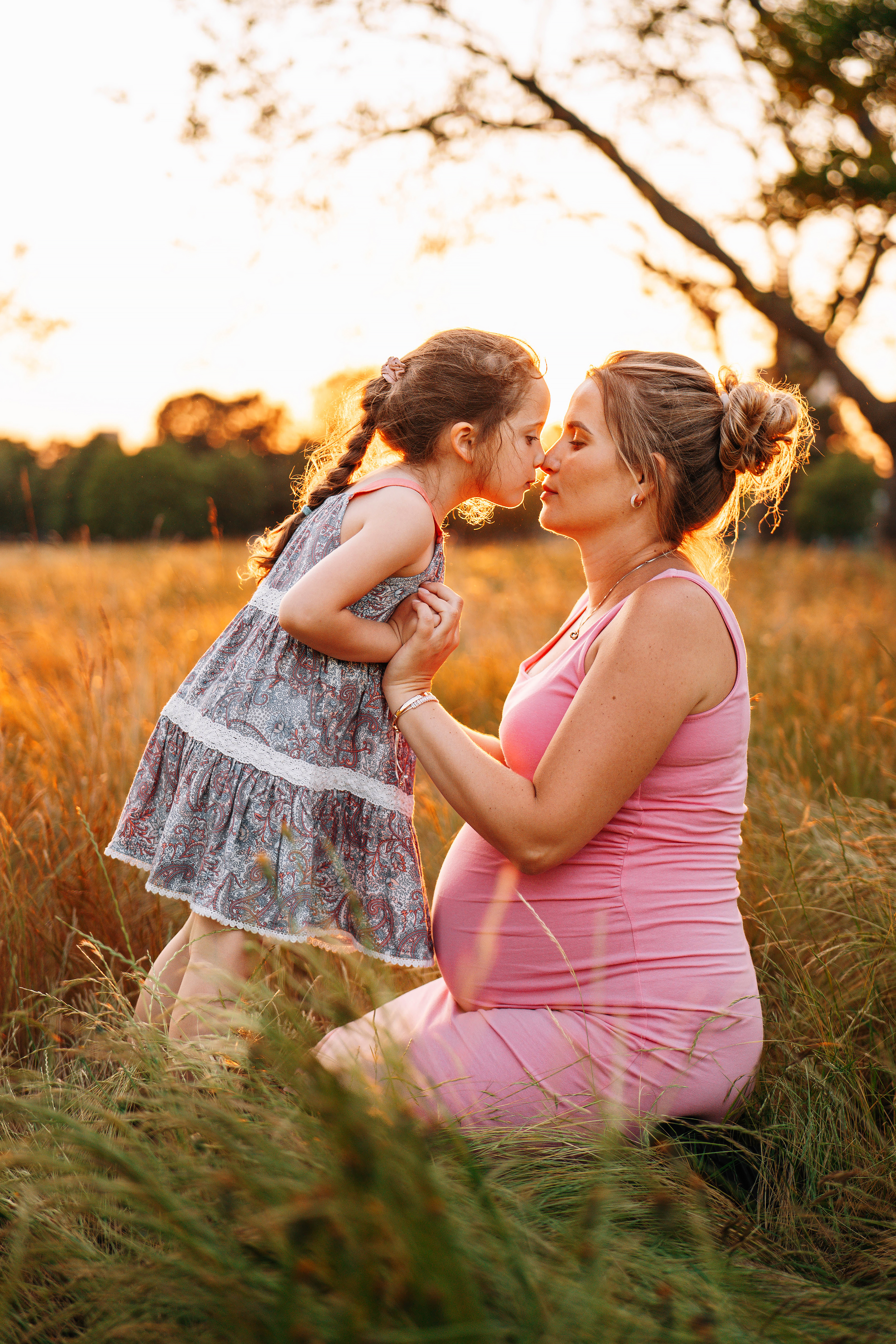Family portrait of a girl and her mother in the park during sunset
