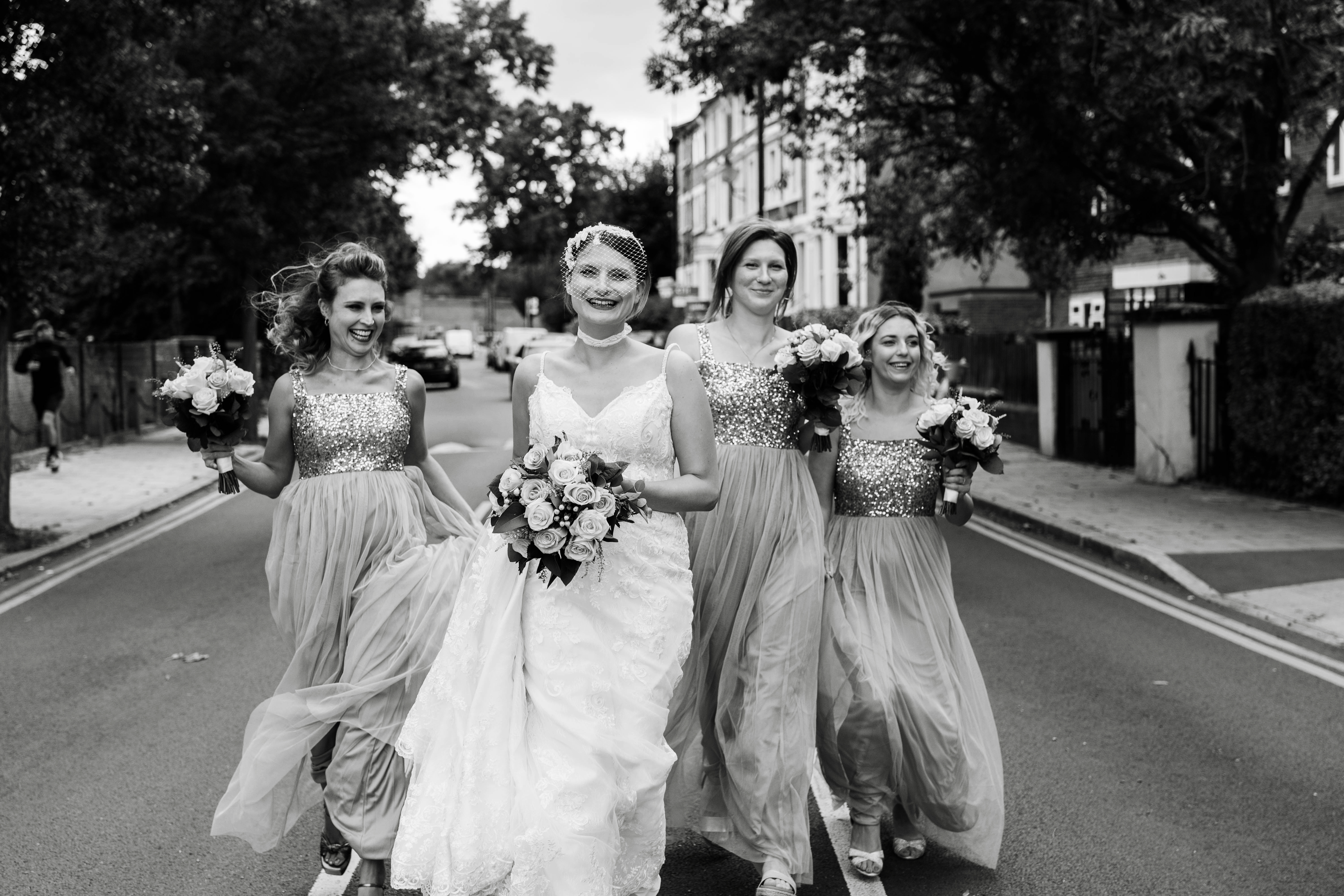 Bride and bridesmaids running on the road
